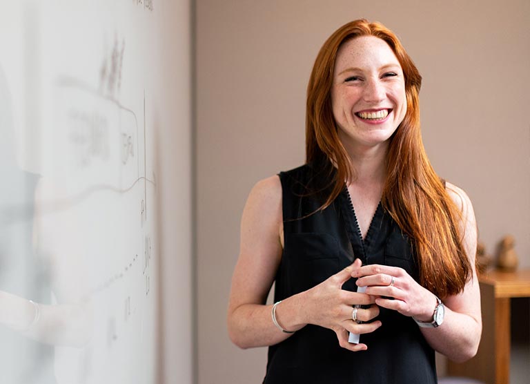 Woman next to white board